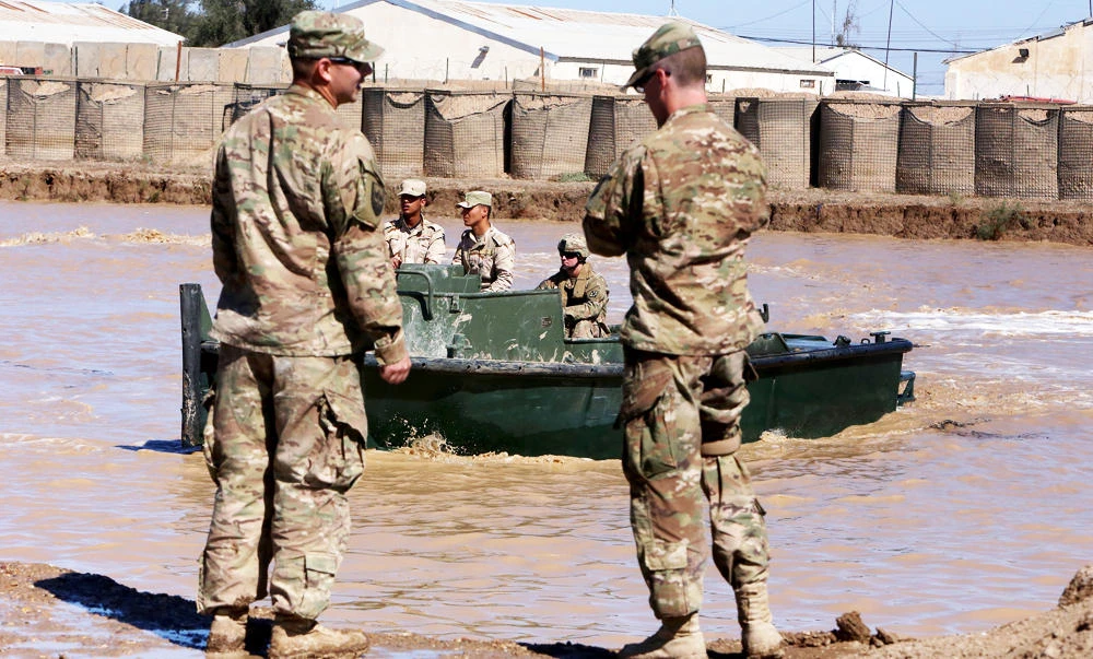 US army forces supervise during a training session at the Taji camp, north of Baghdad, with Iraqi soldiers, aimed at preparing them to install floating bridges, ahead of installing replacement ones in Mosul, on Monday. (AFP)