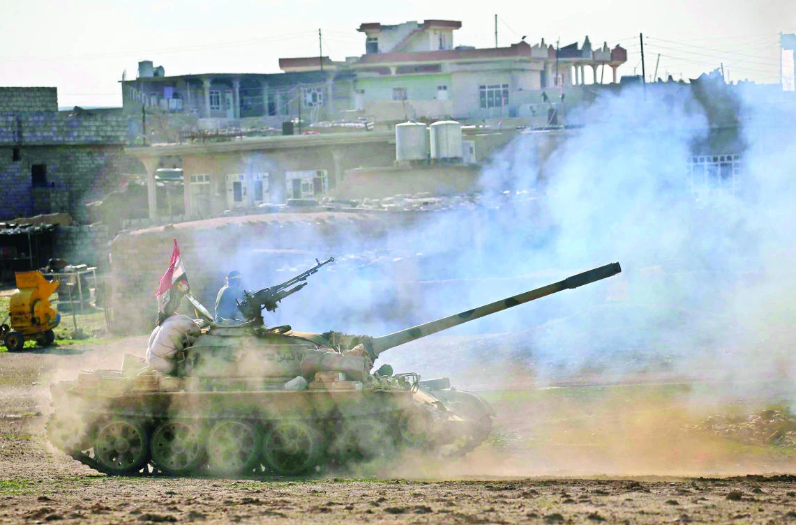 Iraqi government forces supported by Shiite fighters advance in the village of Badush, 15 km from Mosul, Tuesday. (AFP)
