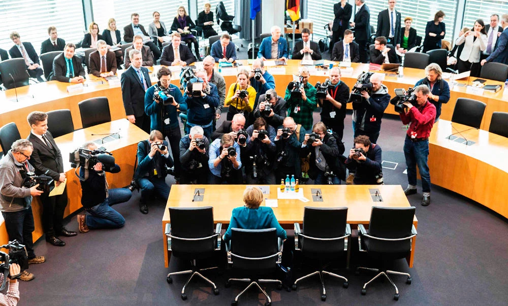 German Chancellor Angela Merkel (C) is in the focus of photographers and cameramen as she waits on Wednesday in Berlin to face a grilling by lawmakers investigating if her government shielded German car maker Volkswagen (VW) from regulators despite knowing the auto giant was carrying out emissions cheating. (AFP)