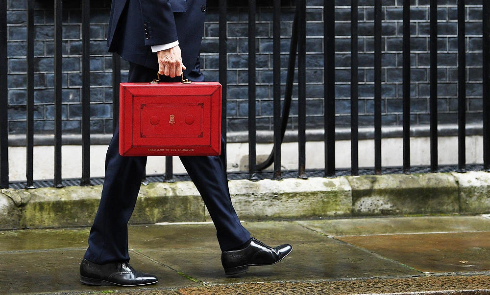 British Chancellor of the Exchequer Philip Hammond poses for pictures with the Budget Box as he leaves 11 Downing Street in London, on Wednesday, before presenting the government's annual Spring budget to parliament. (AFP)