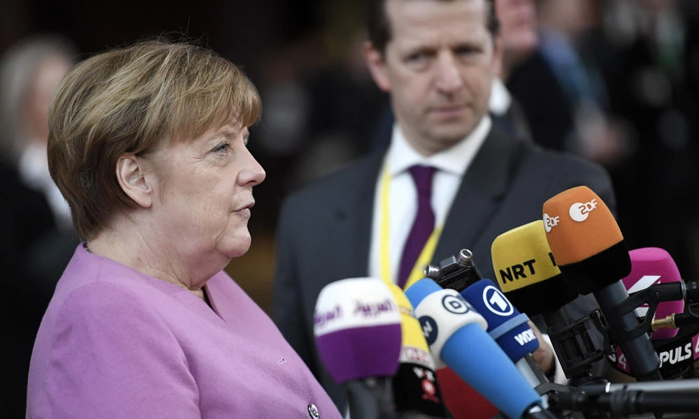 German Chancellor Angela Merkel (L) answers the press as she arrives to attend the EU summit at the new "Europa" building in Brussels on Thursday. (AFP / STEPHANE DE SAKUTIN)