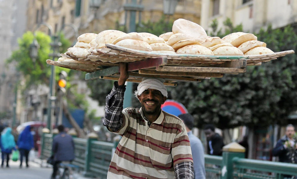 A man carries fresh bread on his head in Cairo, Egypt. (Reuters)