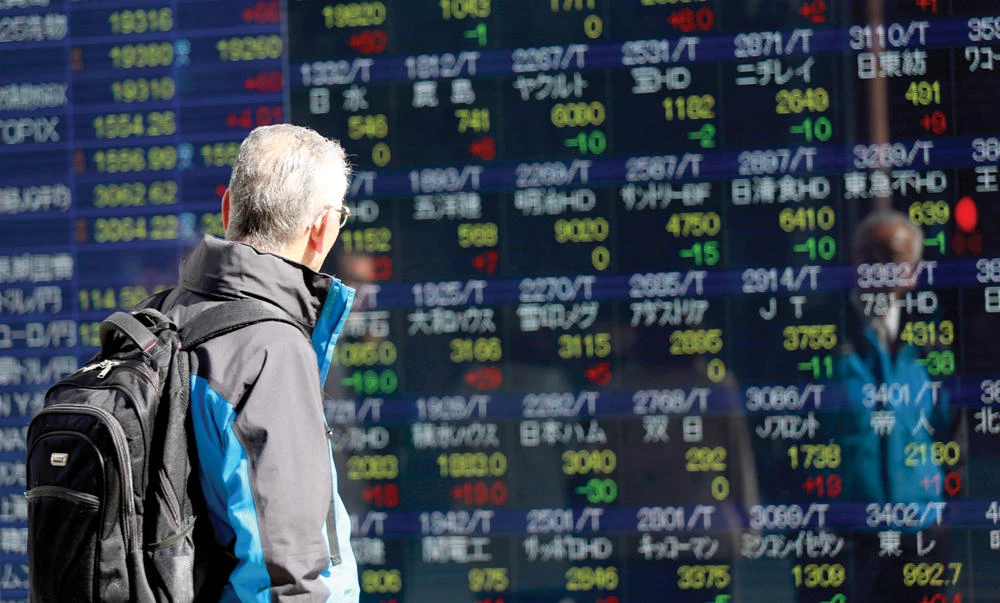 A man looks at an electronic stock board of a securities firm in Tokyo, on Thursday. (AP)