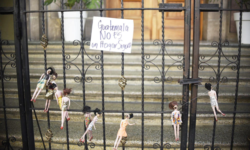 Dolls representing the victims of a fire at the government-run children's shelter in San Jose Pinula, east of Guatemala City,
are seen on the gate of the presidential house on Thursday. (AFP)