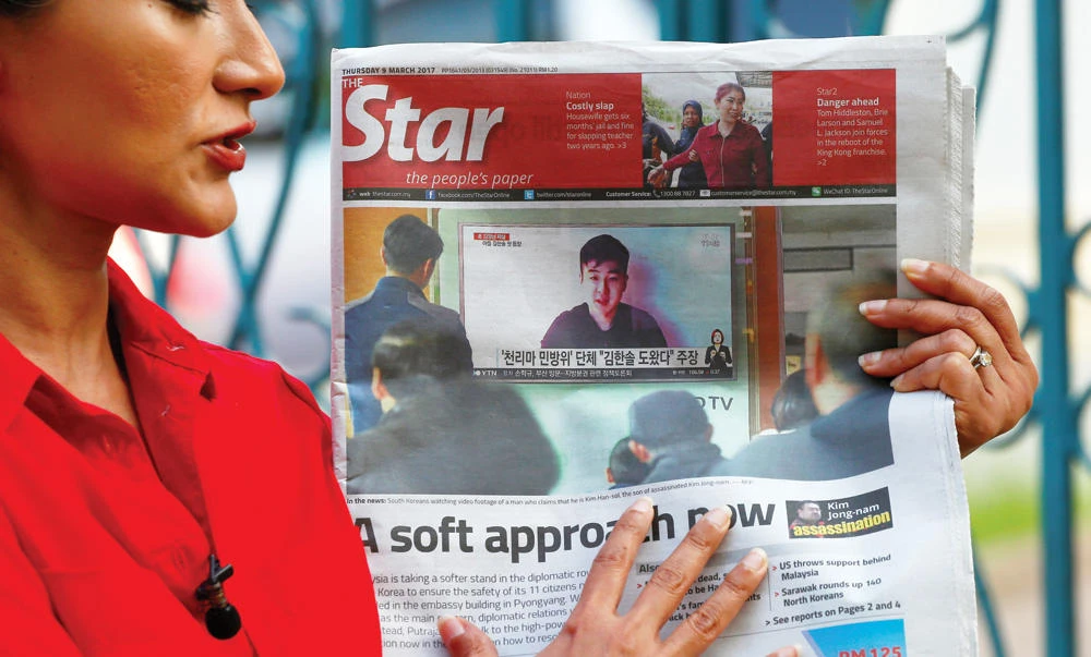 A journalist holds up a newspaper showing a photo of a man who claims to be the son of Kim Jong Nam outside the North Korean Embassy in Kuala Lumpur on Thursday. (Reuters)