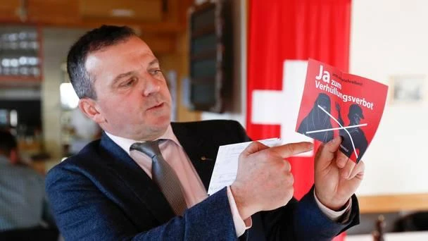 Walter Wobmann displays a leaflet reading “Yes to the ban on veiling” at a meeting of the Swiss People’s Party SVP in Dornach, Switzerland. (AP)
