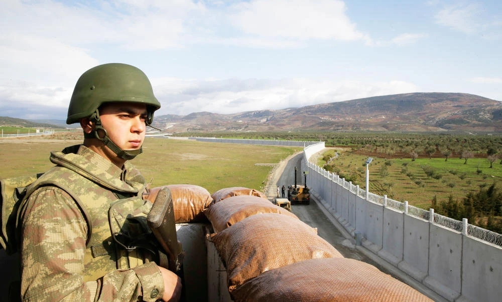 In this March 2, 2017 photo, a Turkish army soldier mans an outpost near the town of Kilis, southeastern Turkey, adjacent to the wall the country had been constructing to boost security along its border with conflict-stricken Syria. (AP)