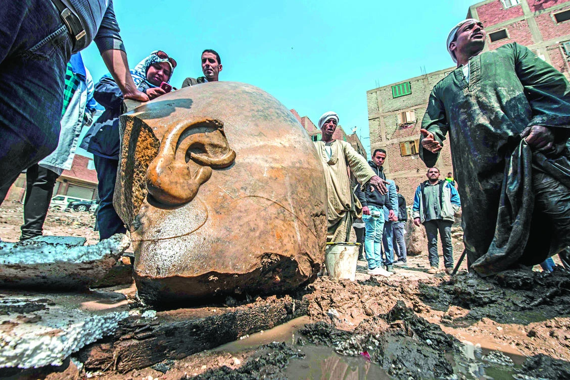 Egyptian workers look at the site of a new discovery by a team of German-Egyptian archaeologists in Cairo’s Mattarya district. (AFP)