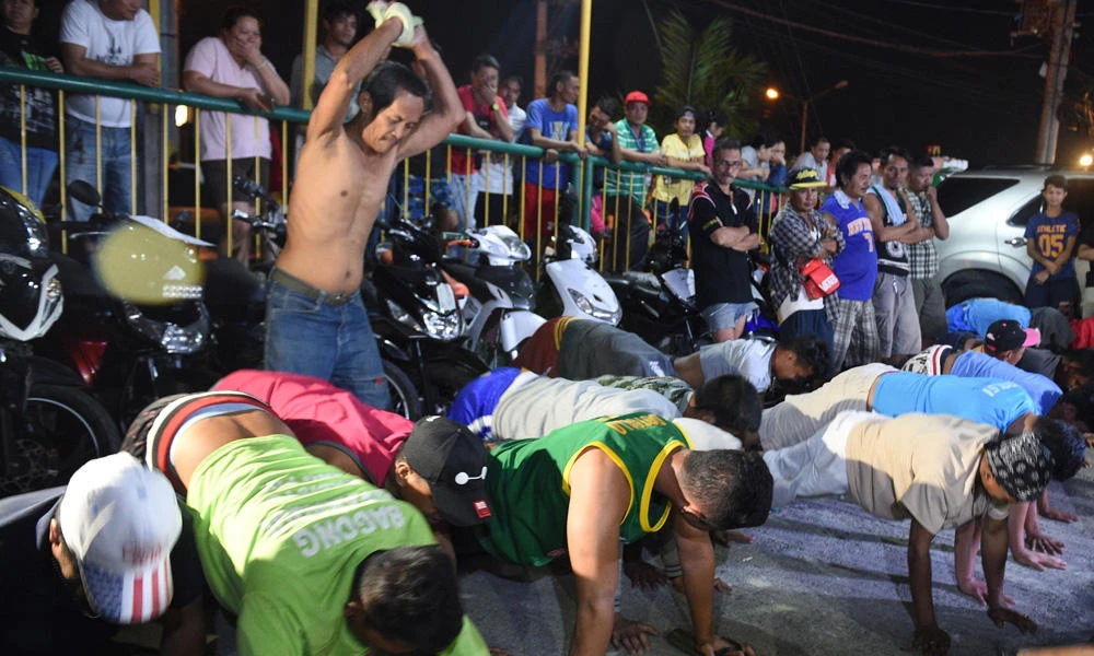 This photo taken March 9, 2017 shows detained bewildered drunks and shirtless men, doing 60 push-ups, as punishement during the police's operation called "Oplan RODY", an acronym for Rid the Streets of Drinkers and Youths, and also President Rodrigo Duterte's nickname, at Paranaque police headquarters, suburban Manila. "OPLAN RODY" is one of police's initiatives getting rid of crimes in the streets in consonance with President Rodrigo Duterte's war on drugs. ( AFP / TED ALJIBE)