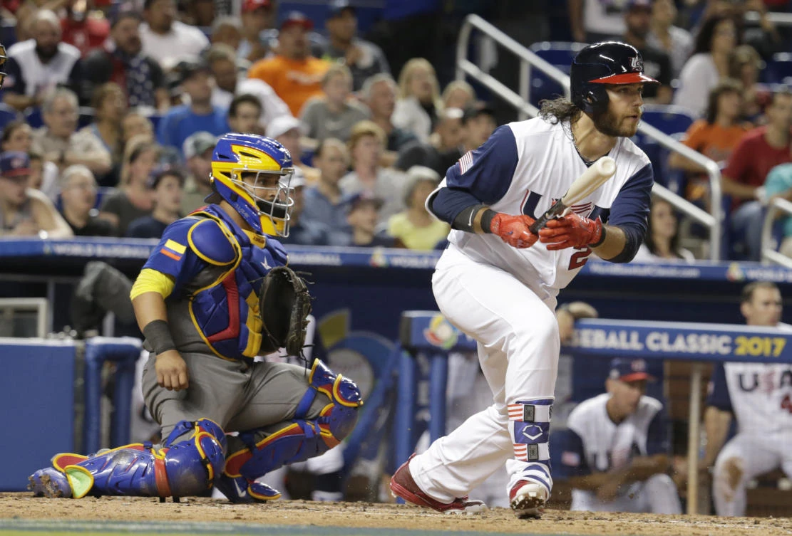 Brandon Crawford, right, follows through on a single as Colombia catcher Jhonatan Solano watches during the sixth inning in a first-round game of the World Baseball Classic, in Miami, on Friday night. (AP)