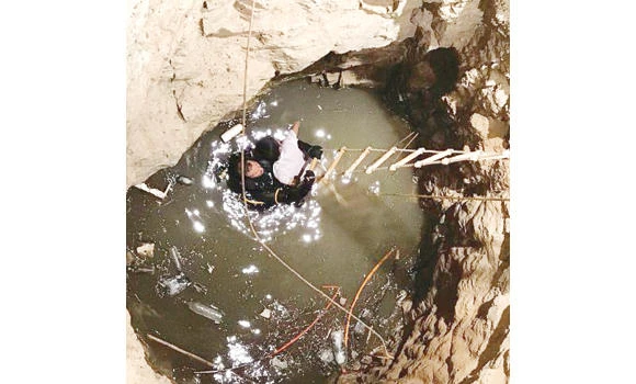 A Civil Defense man is taking out the body of a youth who fell to death in a well in Taif on Friday. (Al-Hayat newspaper)