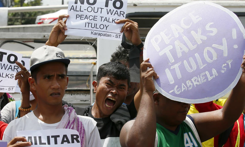 In this March 7, 2017, photo, activists protest in Manila to demand the resumption of peace talks between the government and communist rebels. Both sides agreed to resume negotiations on Sunday. (AP Photo/Bullit Marquez)