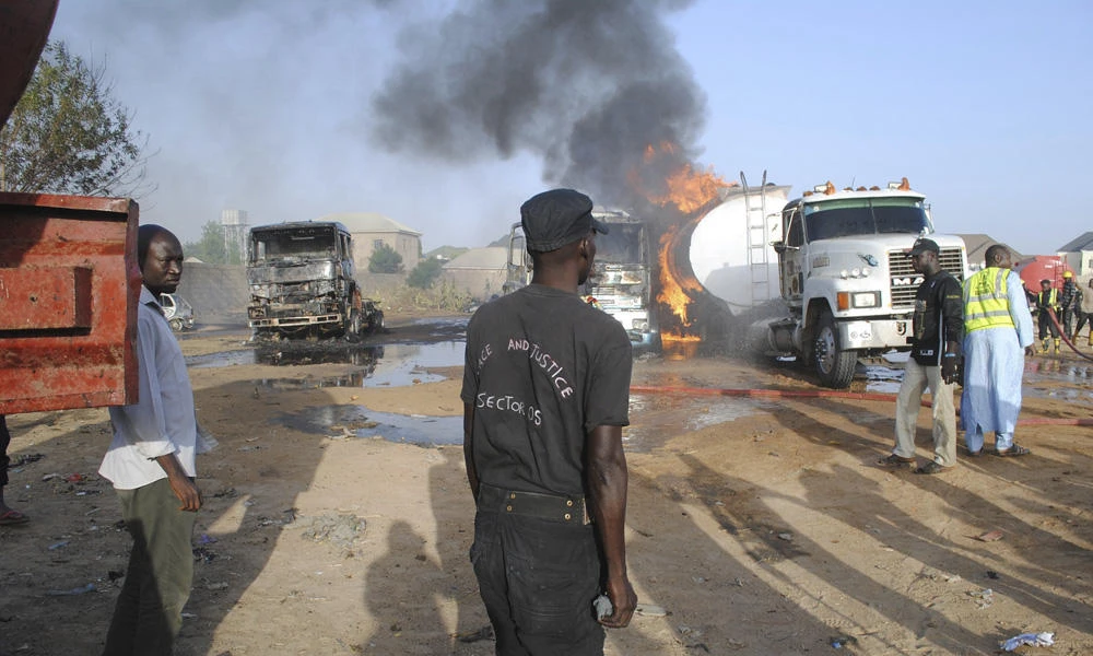 In this March 3, 2017, file photo, firefighters try to contain a blaze following a suicide attack by Boko Haram insurgents on petrol tankers in Maiduguri, Nigeria. On Sunday, two teenage girls believed to be used by the Boko Haram as suicide bombers were shot dead by police before they could detonate the bombs strapped in their bodies. (AP Photo/Jossy Ola)