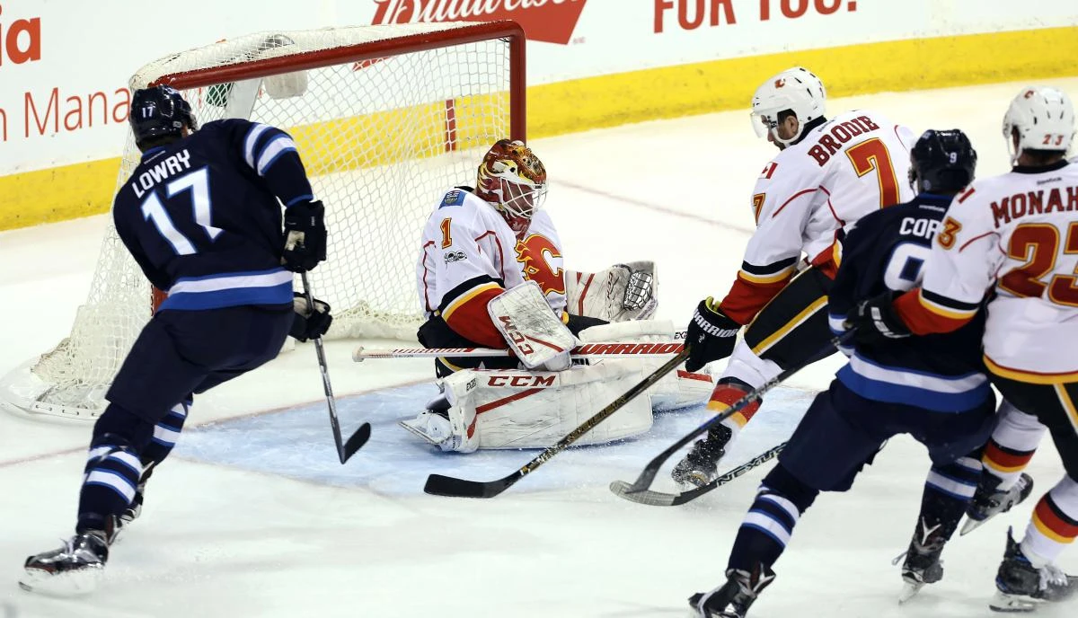 Brian Elliott (1) of the Calgary Flames makes a save off Andrew Copp (9) of the Winnipeg Jets during NHL action at the MTS Centre in Winnipeg, Manitoba, on Saturday night. (AFP)