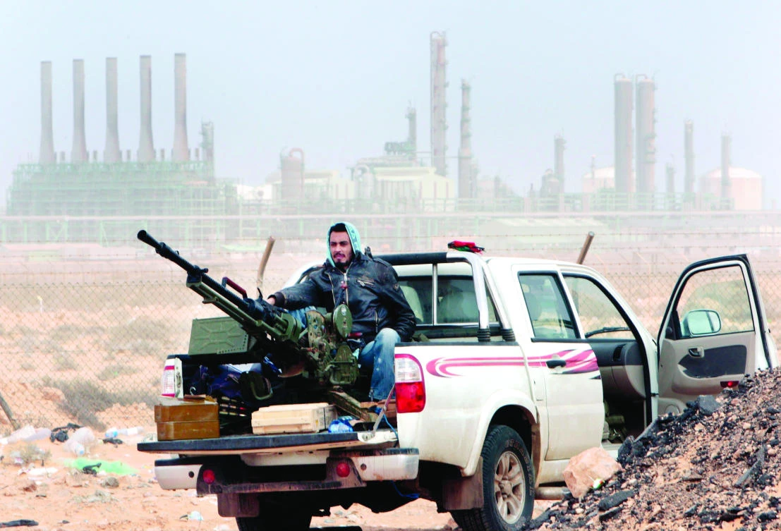 A Libyan rebel sits with an anti-aircraft weapon in front of an oil refinery in Ras Lanouf, eastern Libya, in this file photo. (AP)