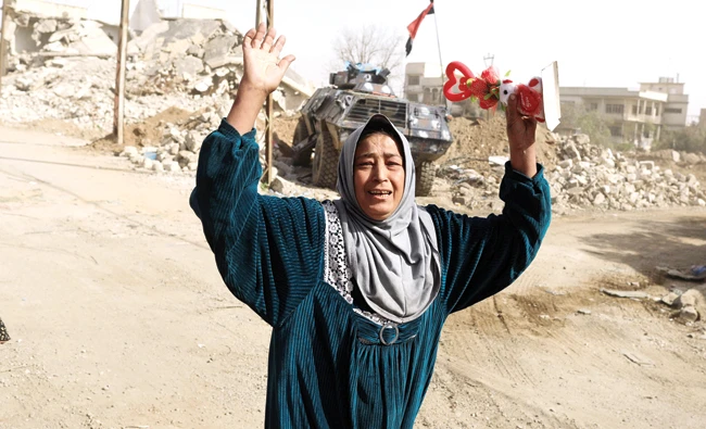A displaced woman reacts as she flees her home, while Iraqi forces battle with Daesh militants, in western Mosul, on Sunday. (Reuters)