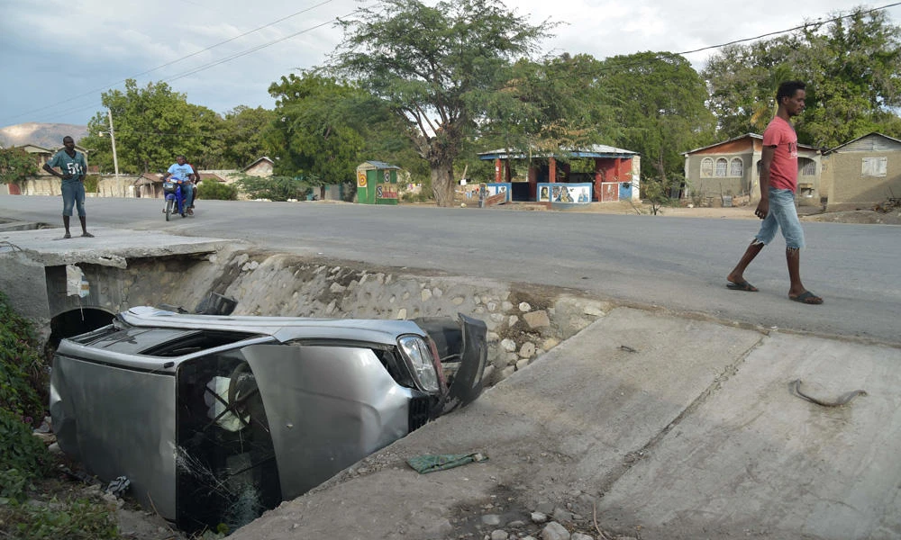 A car damaged by a bus lies on the side of a road on Sunday in Gonaives, 150 km northwest of the capital Port-au-Prince, Haiti. A bus speeding away from a hit-and-run accident plowed into dozens of street musicians in northern Haiti, killing 34 people, officials said. (AFP / HECTOR RETAMAL)