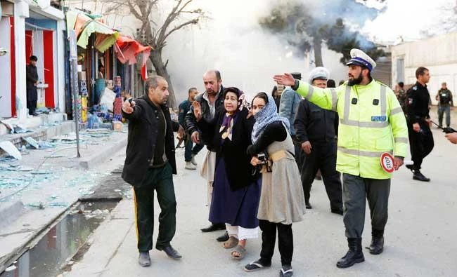 Survivors walk after a blast in Kabul, Afghanistan on Monday. (REUTERS)