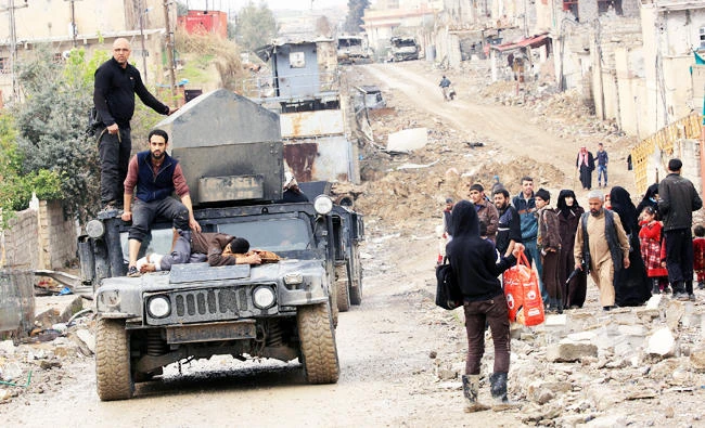 Displaced Iraqi people who fled their homes because of the clashes carry their belongings to go to safe places as Iraqi forces battle with Islamic State militants in Mosul, Iraq, on Monday. (Reuters)