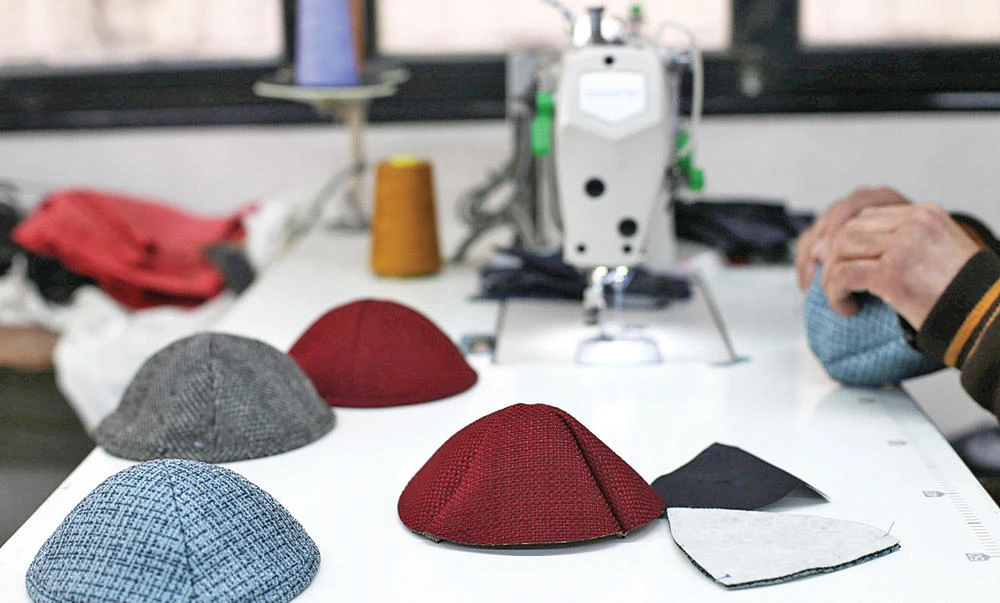 A Palestinian man makes skull caps at a sewing factory in Gaza. (Reuters)