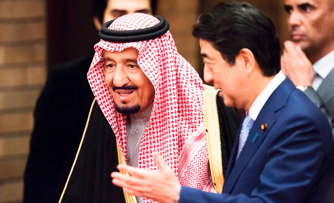 Saudi Arabia's King Salman bin Abdulaziz al-Saud (L) is escorted by Japan's Prime Minister Shinzo Abe (R) during a banquet at Abe's official residence in Tokyo on Monday. (AFP)