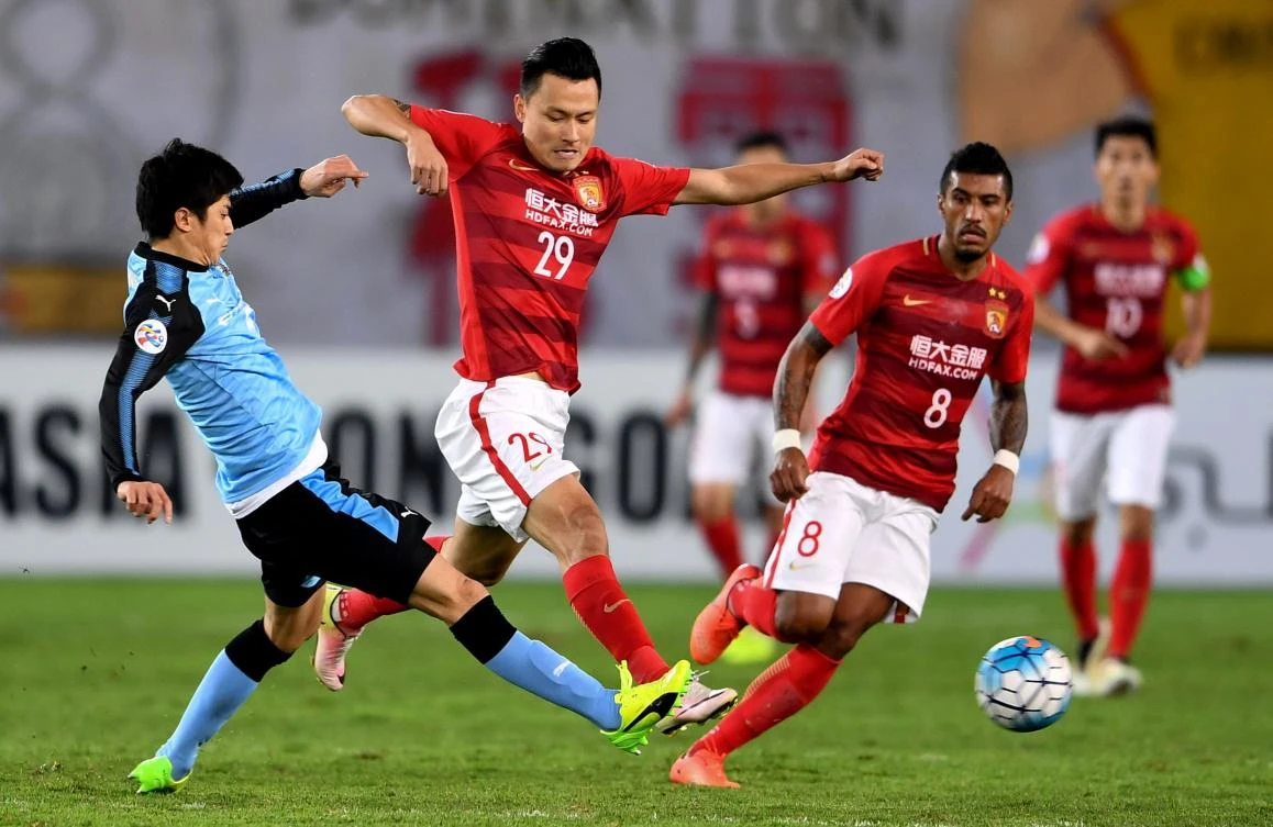 Gao Lin, center, of China's Guangzhou Evergrande fights for the ball with Taniguchi Shogo, left, of Japan's Kawasaki Frontale during their AFC Champions League group stage football match in Guangzhou, in China's Guangdong province on Tuesday. (AFP)