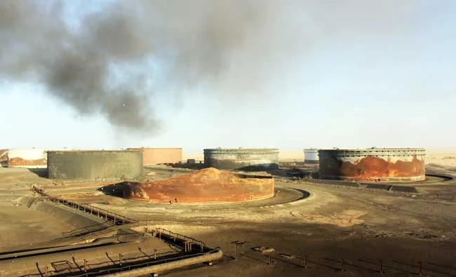 This file photo taken on January 08, 2016 shows smoke billowing from a petroleum storage tank after a fire was extinguished at Al-Sidra oil terminal, near Ras Lanuf in the so-called “oil crescent” along Libya’s northern coast. Troops commanded by Libyan military strongman Khalifa Haftar launched an assault on March 14, 2017 to seize two of the country’s key eastern oil terminals, a spokesman said. (AFP)
