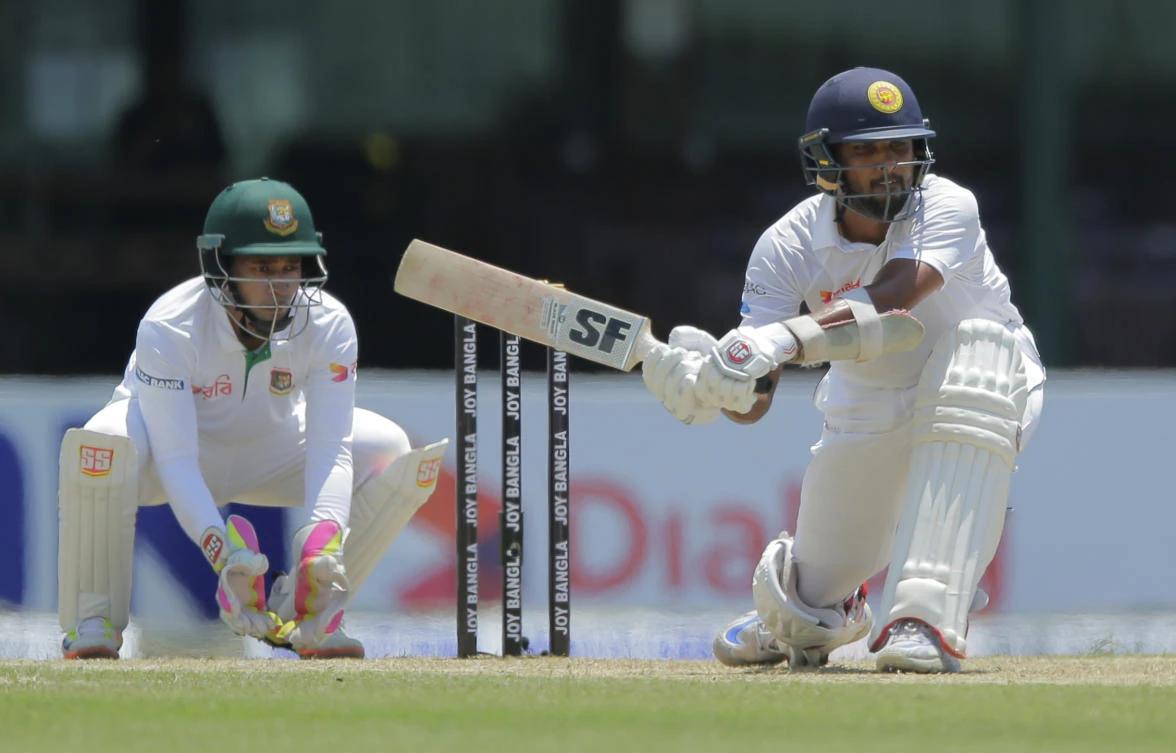 Sri Lanka's Dinesh Chandimal plays a shot as Bangladesh wicketkeeper Mushfiqur Rahim watches on day-one of their second Test match in Colombo on Wednesday. (AP)