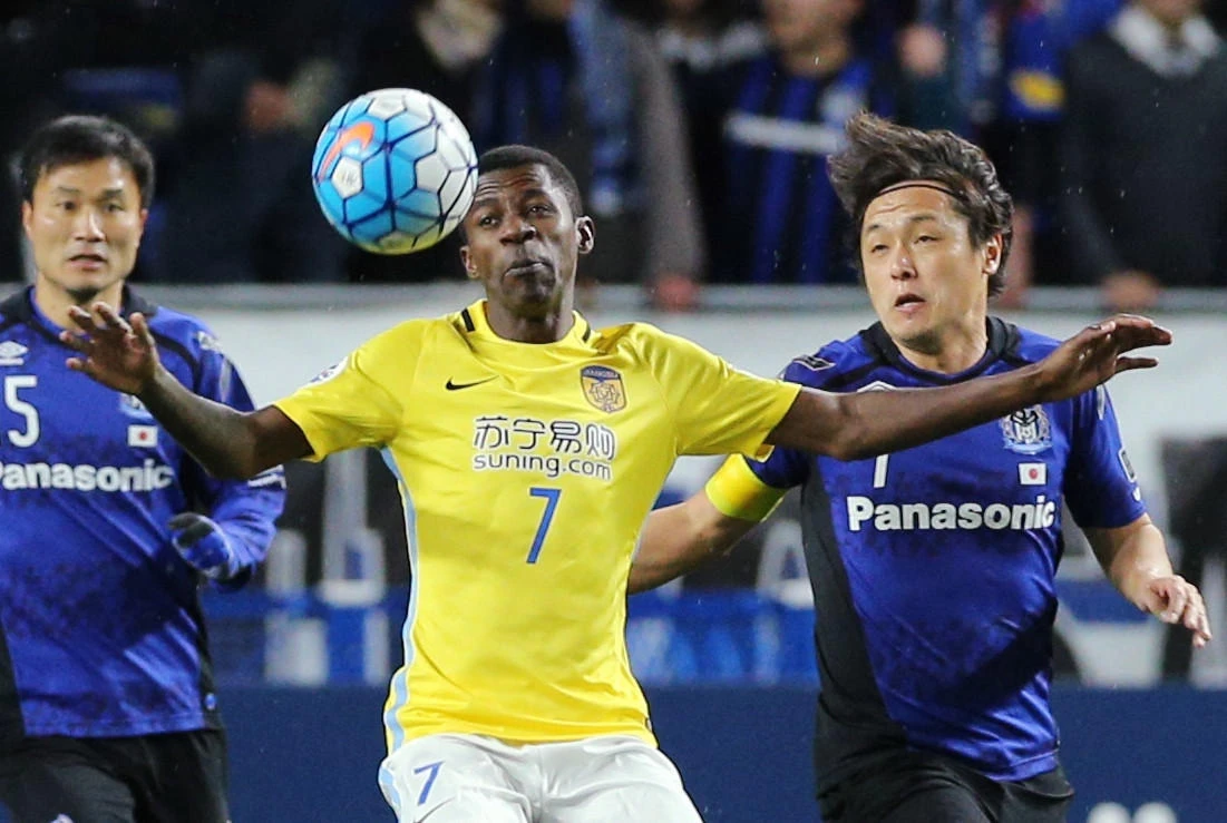 Gamba Osaka defender Daiki Niwa, left, and midfielder Yasuhito Endo, right, fight for the ball with Jiangsu Suning midfielder Ramires Santos, center, during the AFC Champions League matchin Suita City stadium in Osaka on Wednesday. (AFP)