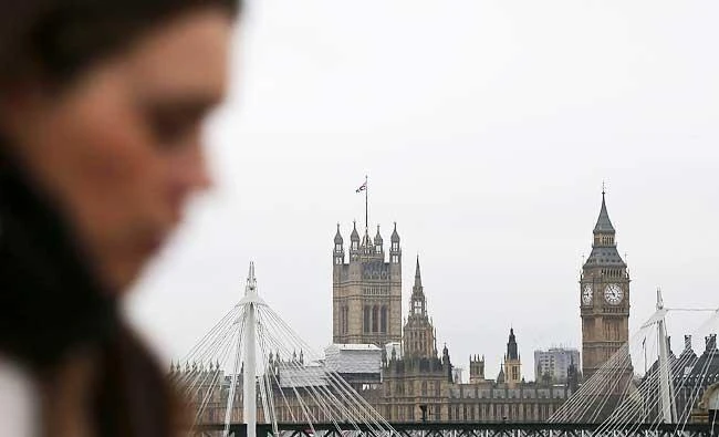 A commuter walks across Waterloo Bridge, backdropped by The Elizabeth Tower, better known as "Big Ben", and the Houses of Parliament, in central London on Wednesday. (AFP)