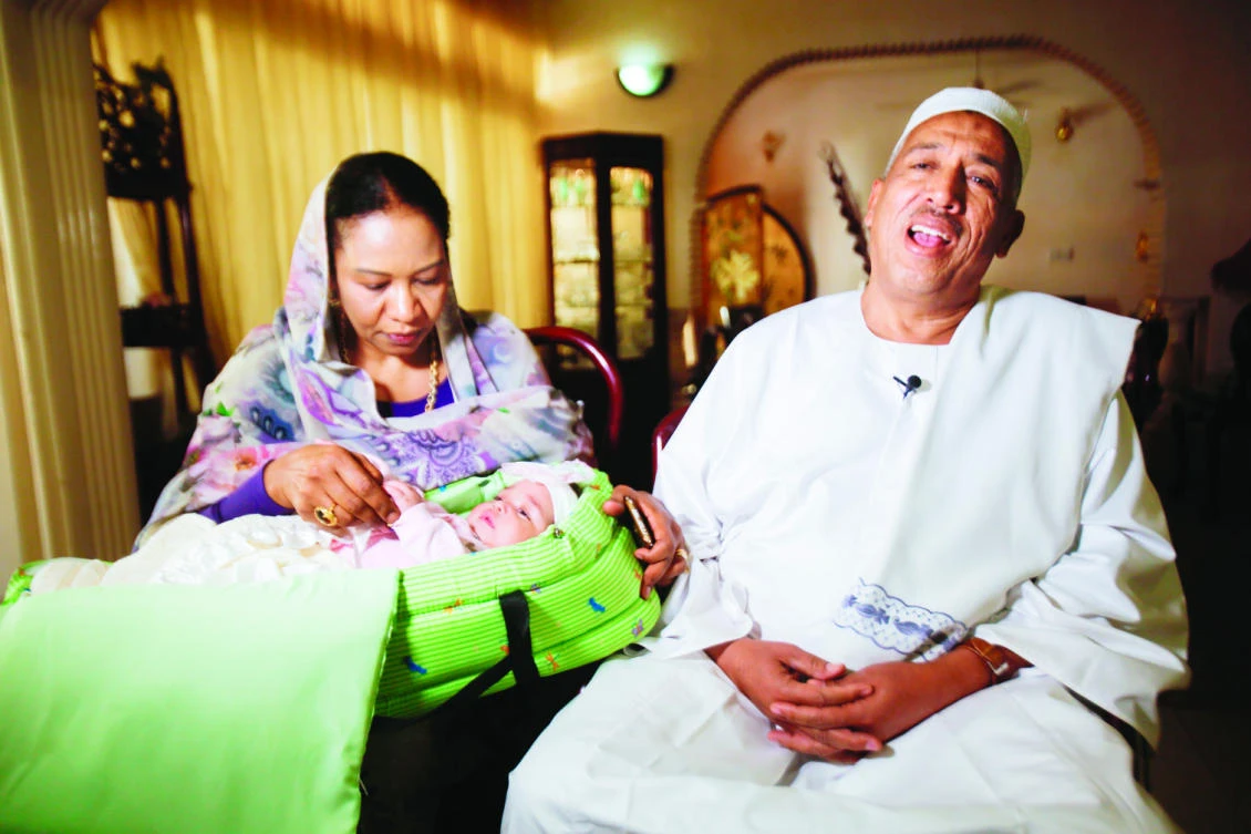Sudanese businessman Alithi Yousef and his wife Manal
Fadlallah hold their four-month-old granddaughter Lojien at
their home in a suburb of the capital Khartoum. (AFP)