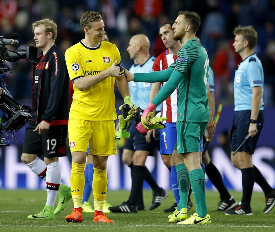 Leverkusen goalkeeper Bernd Leno, left, lifts a thumb as he says good bye to Atletico goalkeeper Jan Oblak, right, after the Champions League match in Madrid on Wednesday night. (AP)