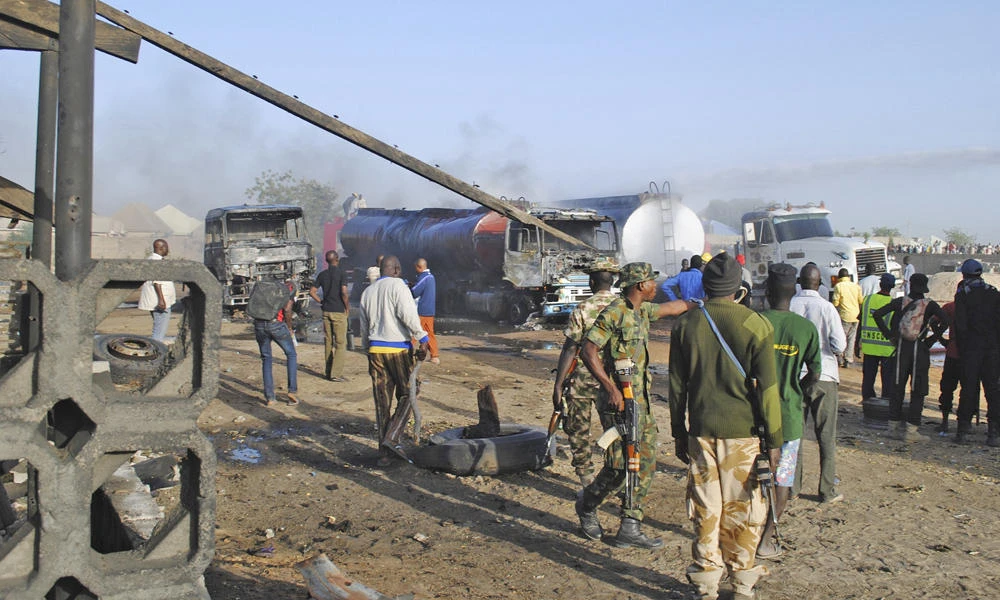 Security forces stand guard as firefighters try to contain a fire following a Boko Haramsuicide attack at a petrol tankers in Maiduguri, Nigeria, on March 3, 2017. Militants on Thursday raided a town near Maiduguri, looting food supplies. (AP Photo/Jossy Ola)