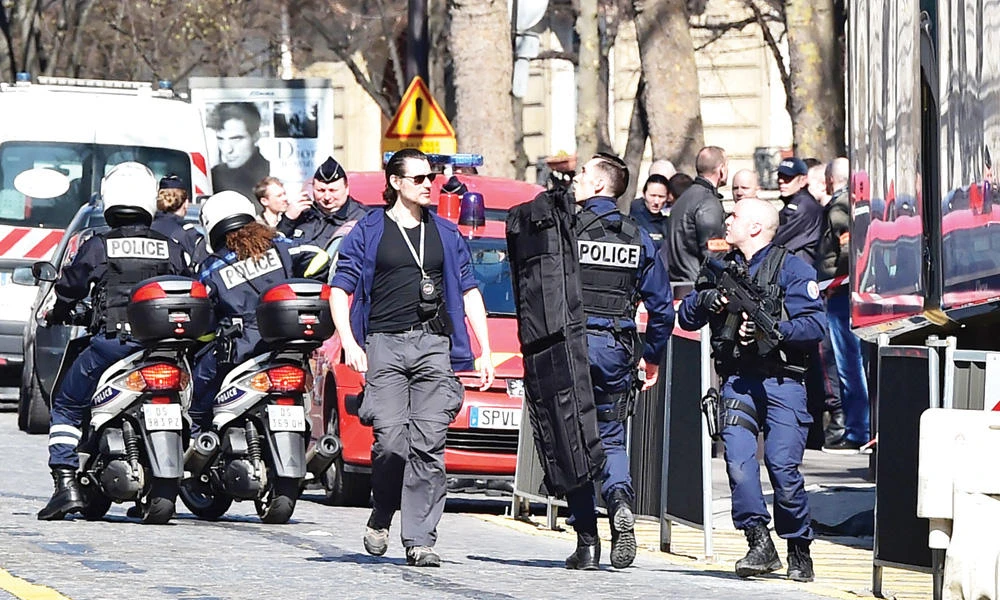 French police officers secure the scene near the Paris offices of the International Monetary Fund (IMF) after a letter bomb exploded in the premises, on Thursday. (AFP)