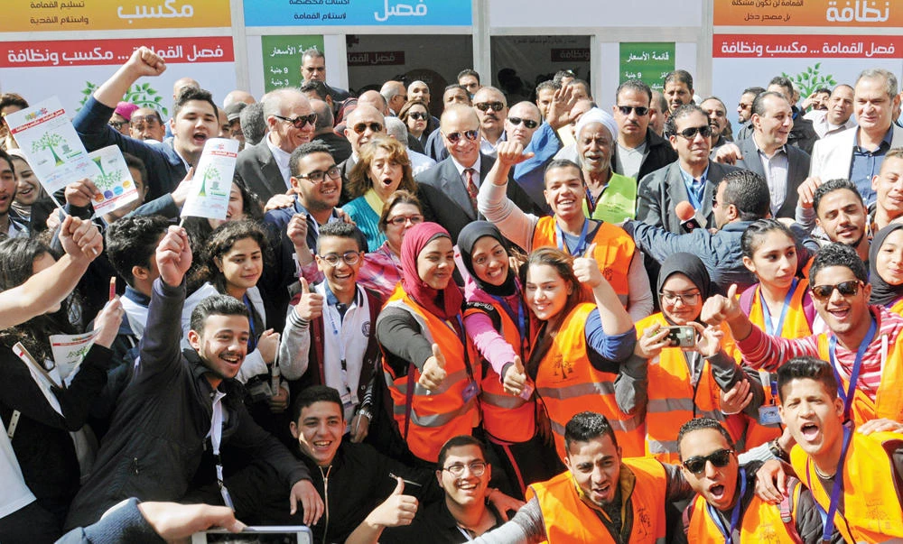 Cairo Gov. Atef Abdelhamid, center, stands in the middle of a crowd at the opening of a center that offers residents money in exchange for their recyclable garbage in an attempt to keep the streets clean in Cairo, on Saturday. (Reuters)