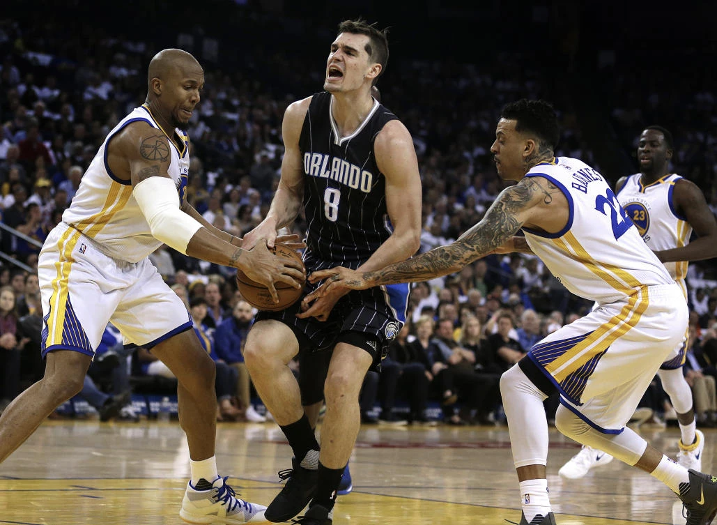 Golden State Warriors' David West, left, steals the ball from Orlando Magic's Mario Hezonja (8) as Warriors' Matt Barnes, right, defends during the first half of an NBA basketball game in Oakland, California, on Thursday night. (AP)