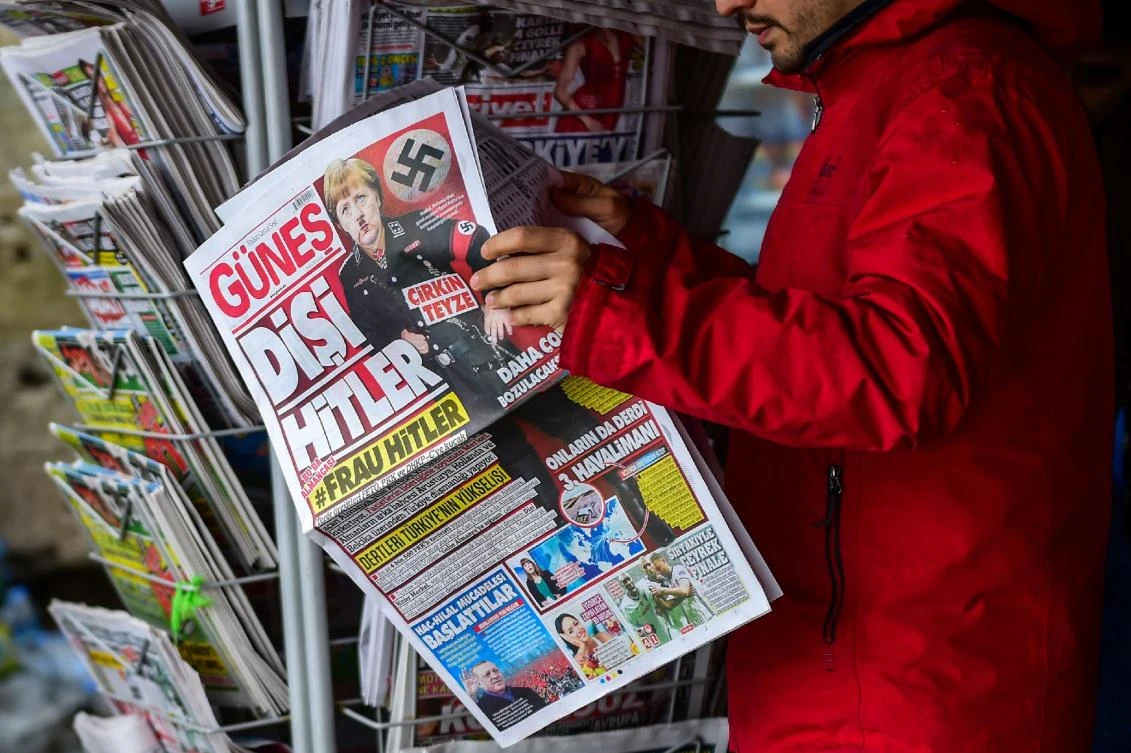 Right-wing tabloid-style daily Gunes (“Sun“) printed the picture along with the words in German: “#Frau Hitler” and called her an “ugly aunt.” The mocked-up image took up most of the front page of the daily, with a Nazi swastika on Merkel’s “uniform” and another swastika next to her head while she is shown holding a gun. (AFP)