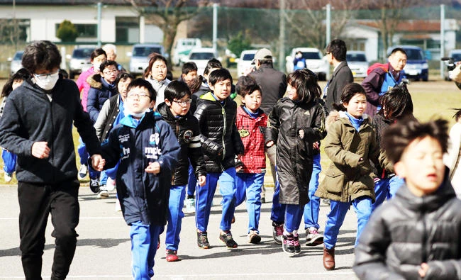 Elementary school students and others take shelter during an evacuation drill in Oga, Aomori prefecture, northern Japan on Friday. (AP)
