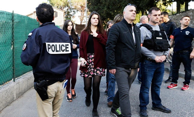 Children, center, leave their high school after an attack in a high school in Grasse, southern France, on Thursday. (AP)