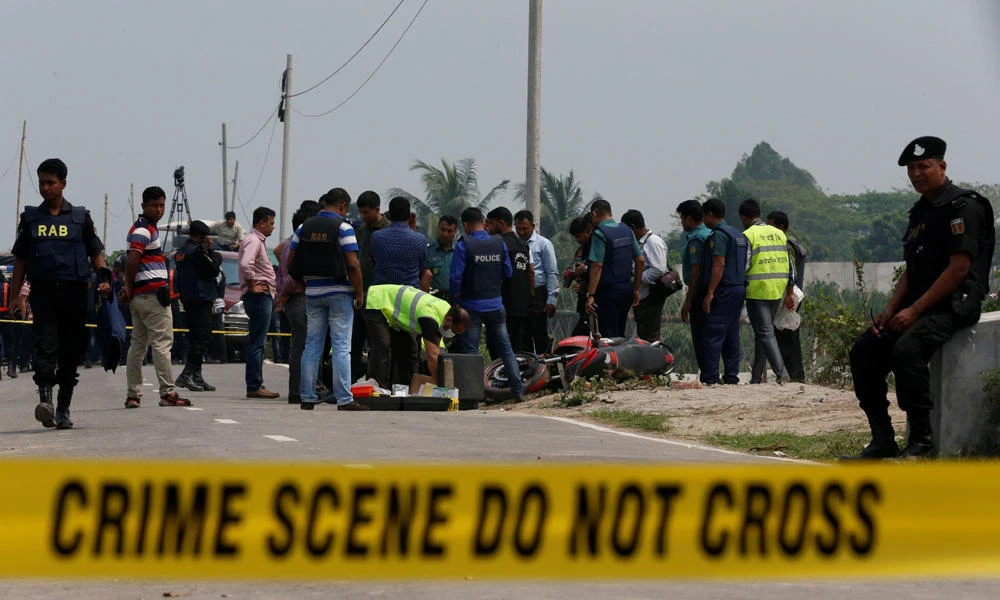 Crime Scene Unit works on the spot where police shot dead a suspected militant who tried to enter a security checkpost on a motorcycle armed with explosives in Khilgaon, outskirt of Dhaka, Bangladesh, on Saturday. (REUTERS/Mohammad Ponir Hossain)