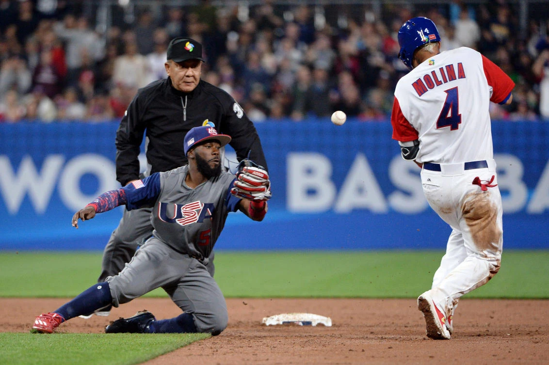 Puerto Rico catcher Yadier Molina (4) reaches second base on an error by US infielder Brandon Crawford (26) during the WBC at Petco Park on Friday night. (USA TODAY Sports)
