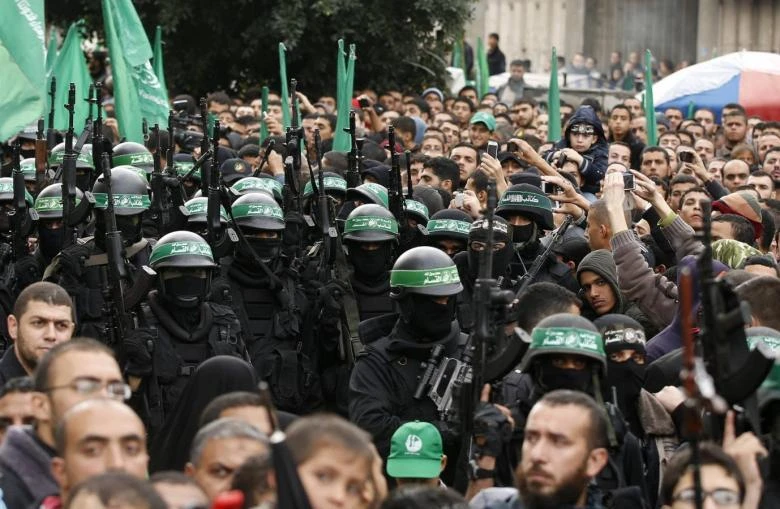 People watch as Palestinian members of al-Qassam Brigades, the armed wing of the Hamas movement, take part in a military parade. (REUTERS)