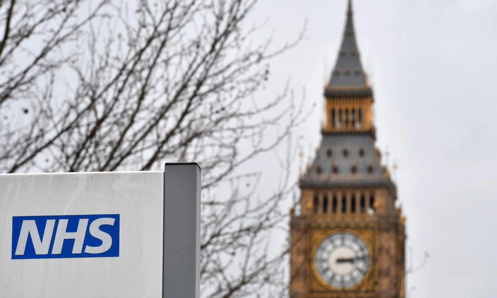 A NHS (National Health Service) sign is pictured outside St Thomas' Hospital, near the Houses of Parliament London on March 8, 2017. (AFP / BEN STANSALL)