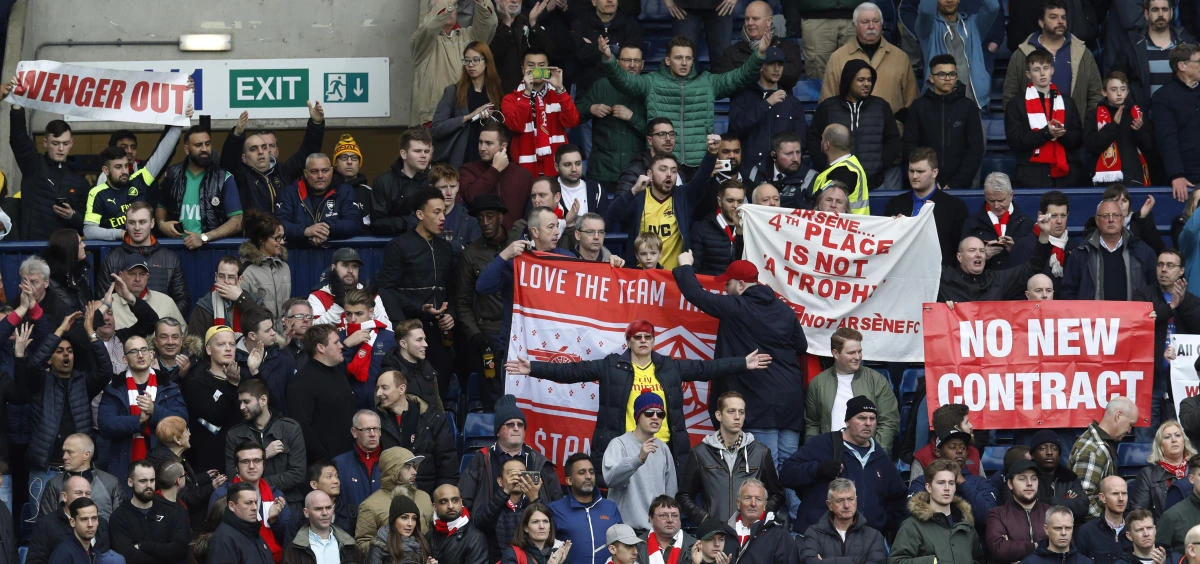 Arsenal fans hold up banners directed at manager Arsene Wenger at the end of the match against West Bromwich on Saturday. (Reuters)