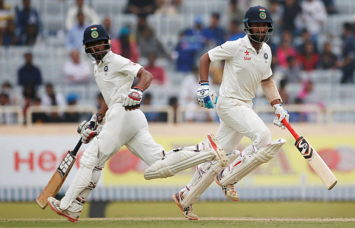 India's Cheteshwar Pujara, right, and Wriddhiman Saha run between the wickets during the third Test against Australia at the Jharkhand State Cricket Association Stadium, Ranchi, on Sunday. (Reuters)