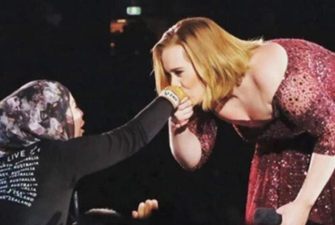 During a concert in Sydney, Adele reached out to kiss the hand of a hijab-wearing fan. (Photo courtesy: Twitter)
