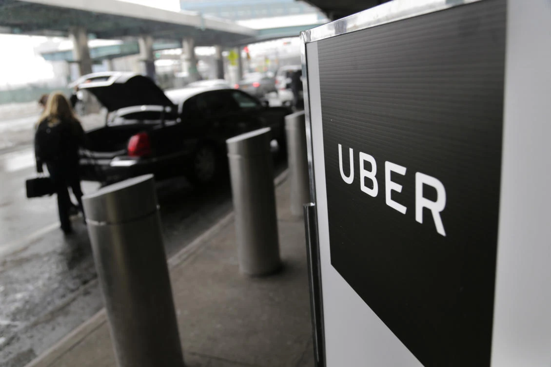 A sign marks a pick-up point for the Uber car service at LaGuardia Airport in New York. (AP Photo/Seth Wenig, File)
