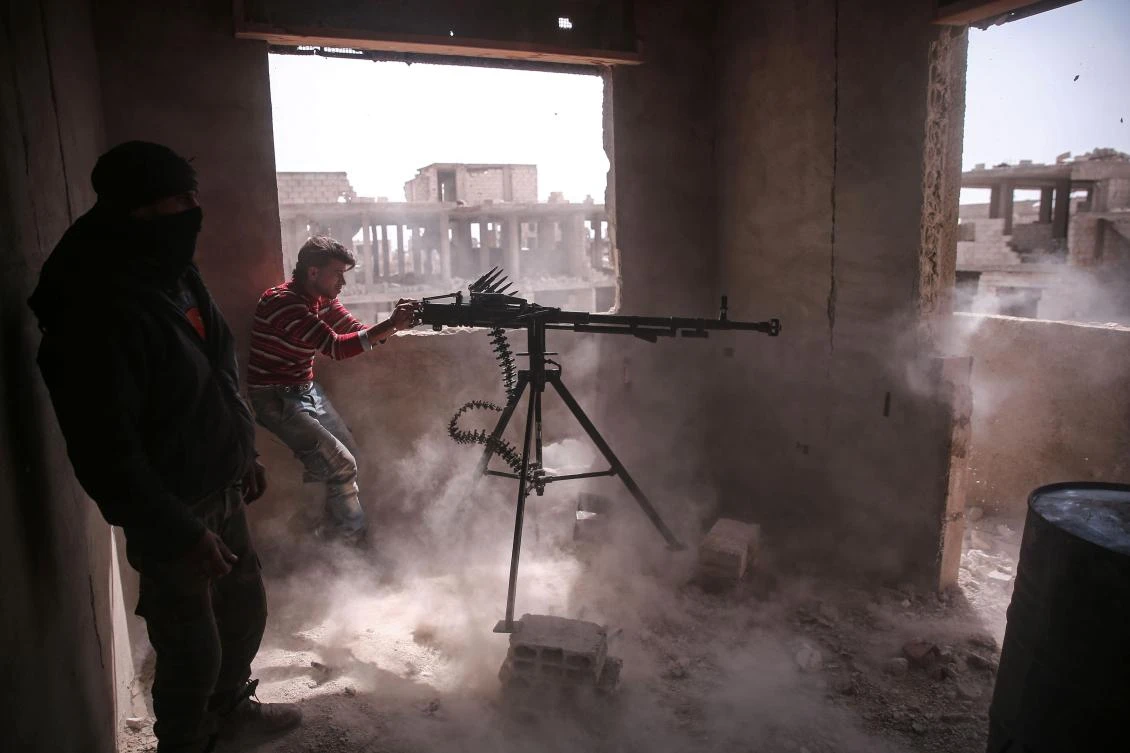 An opposition fighter fires a machine gun in Jobar, on the outskirts of Damascus. (AFP)
