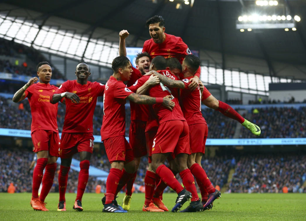 Liverpool players celebrate after scoring the opening goal against Manchester City during the English Premier League soccer match at the Etihad Stadium in Manchester on Sunday night. (AP)