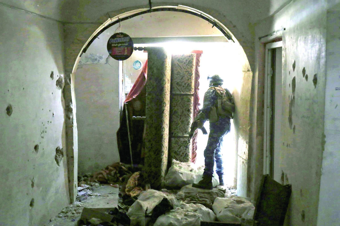 An Iraqi soldier secures a building as troops advance in the Old City in western Mosul during the offensive to retake the city from Daesh. (AFP)
